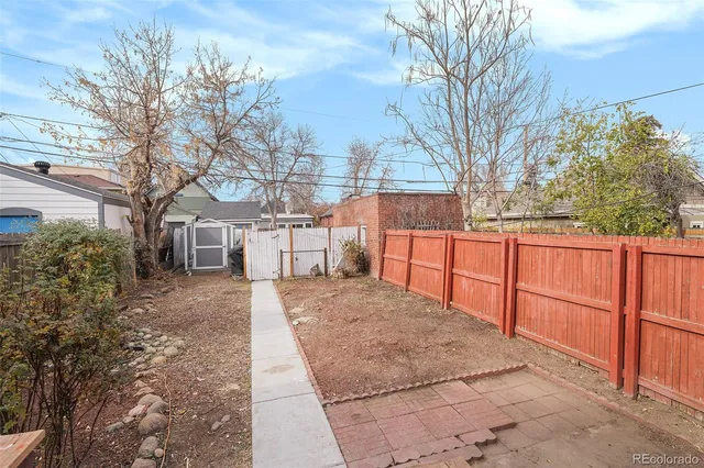 a view of a yard with wooden fence and a large tree