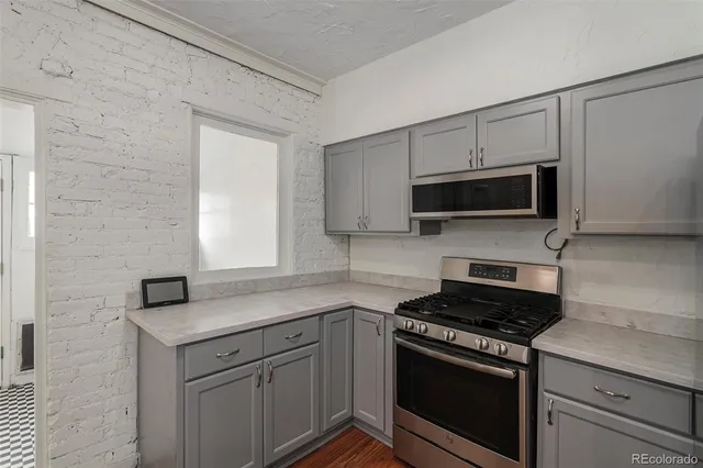 a kitchen with stainless steel appliances granite countertop white cabinets a stove top oven and granite counter tops