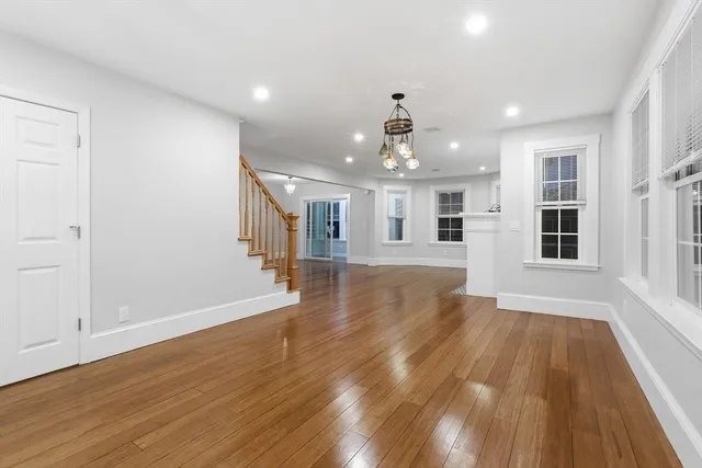 a view of a big room with wooden floor and windows