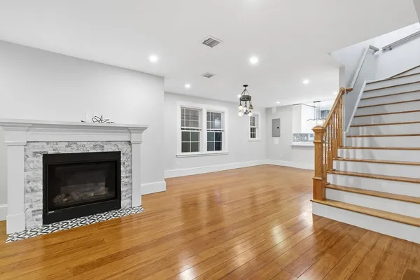 a view of a livingroom with wooden floor and a fireplace