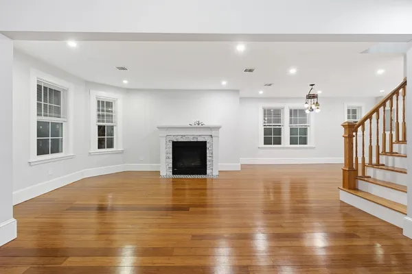 a view of empty room with wooden floor and fireplace