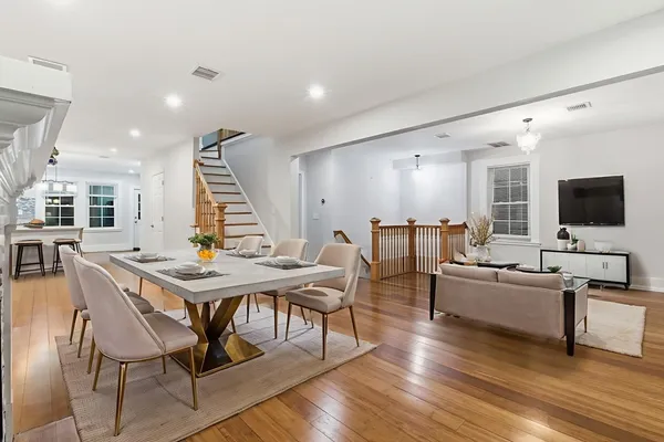 a living room with furniture a flat screen tv and kitchen view