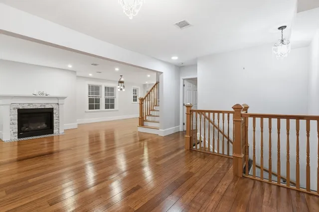 a view of a livingroom with wooden floor and a fireplace