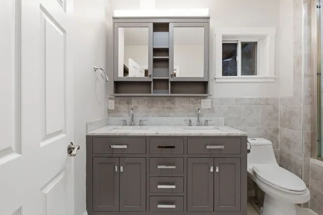 a bathroom with a granite countertop toilet sink and mirror