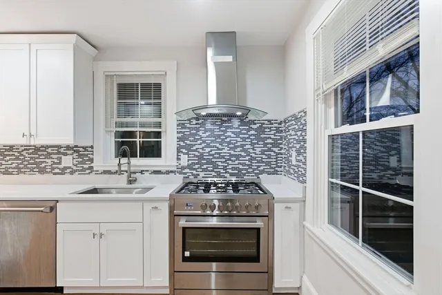 a kitchen with granite countertop white cabinets and white appliances