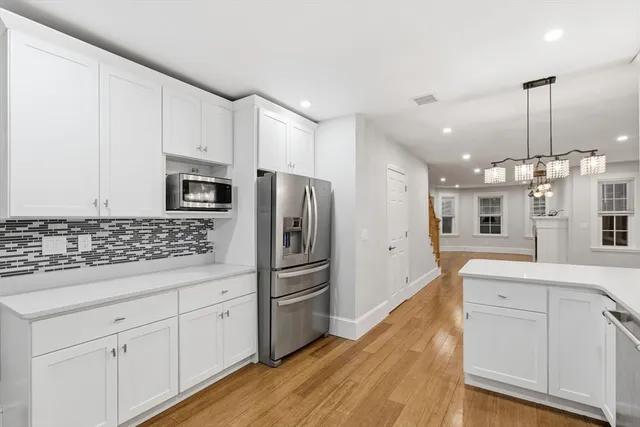 a kitchen with white cabinets and stainless steel appliances