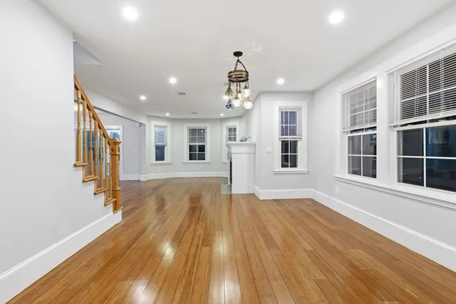 a view of empty room with wooden floor and windows