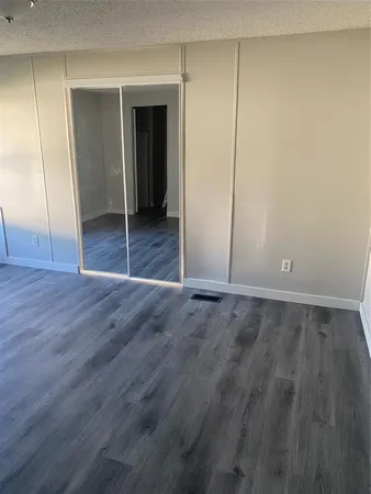 an empty room with wooden floor and closet