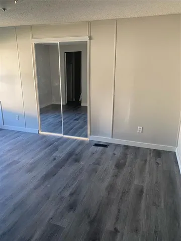 an empty room with wooden floor and closet