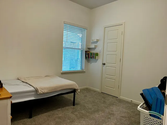 a bedroom with a bed and a window