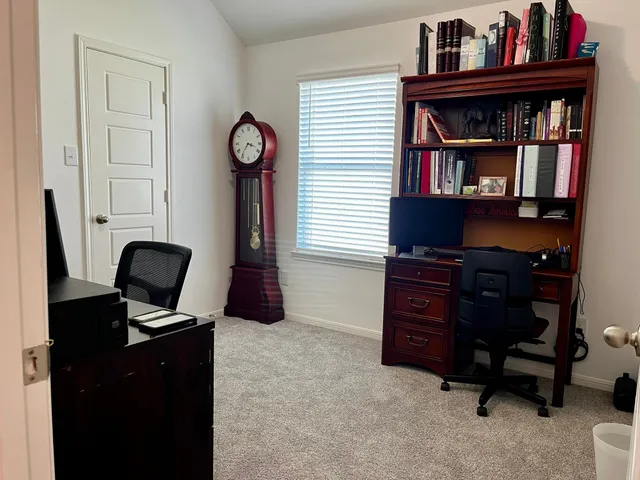 a view of a workspace with furniture and a book shelf