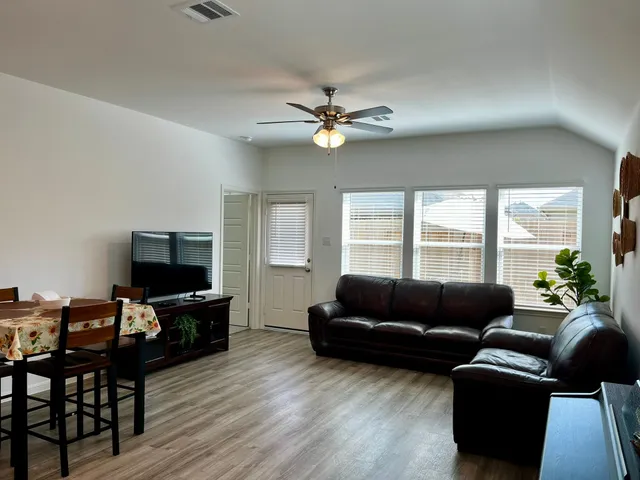 a living room with furniture flat screen tv and a window