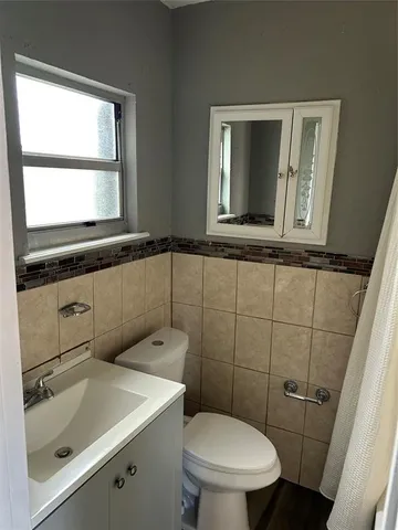a bathroom with a sink a toilet and a window
