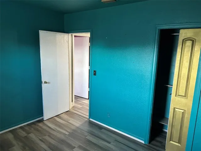 an empty room with wooden floor and entrance