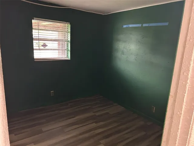a view of a small space with wooden floor and a window