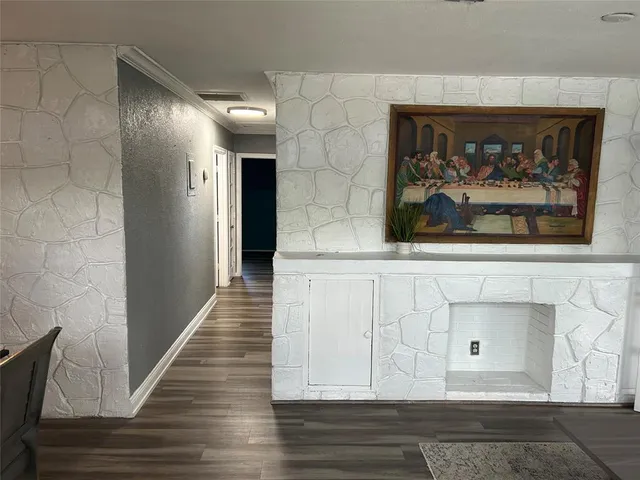 a view of a hallway with wooden floor and a fireplace