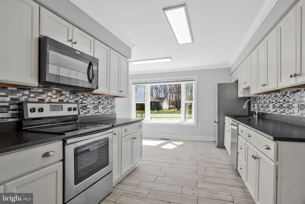 a kitchen with white cabinets and stainless steel appliances