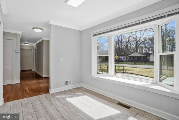 a view of a room with wooden floor and kitchen view