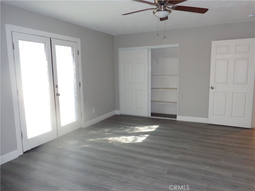 12744 Running Deer Road Apple Valley, CA 92308 - Photo 13 of 30 a view of an empty room with a window and a ceiling fan