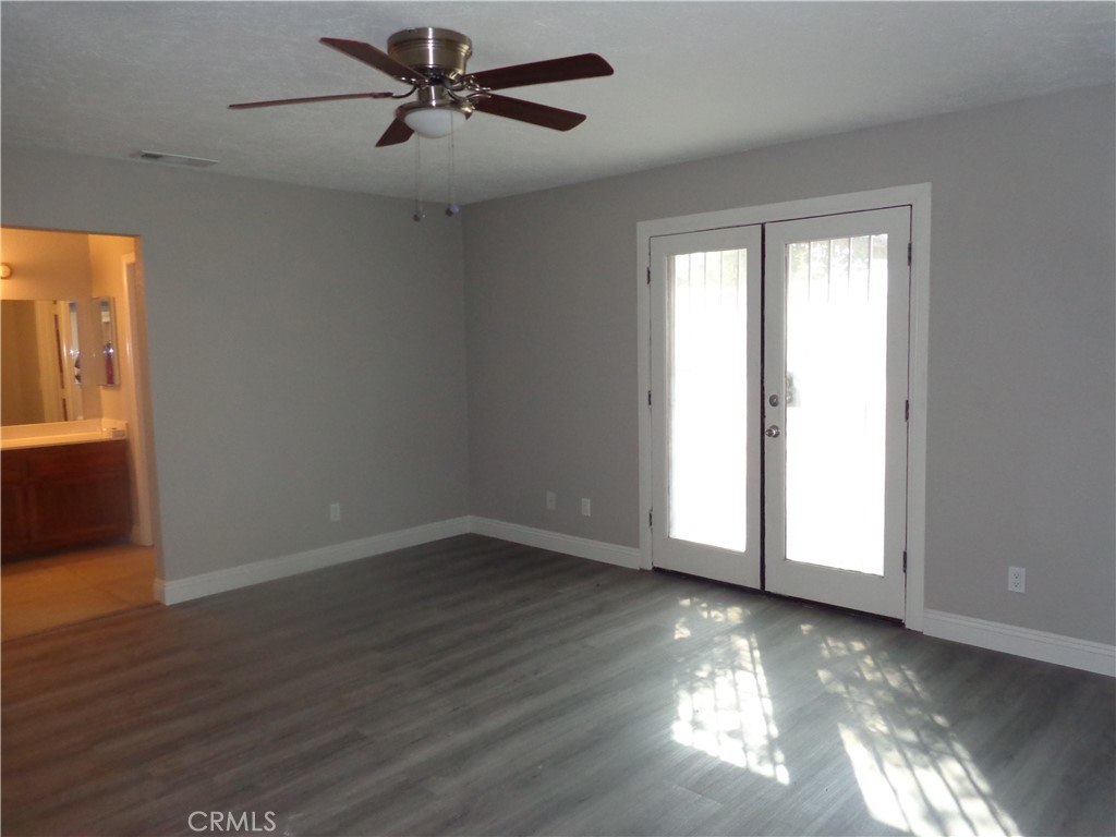 12744 Running Deer Road Apple Valley, CA 92308 - Photo 17 of 30 a view of an empty room with a window and wooden floor