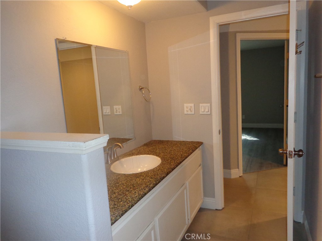 12744 Running Deer Road Apple Valley, CA 92308 - Photo 19 of 30 a bathroom with a granite countertop sink and a mirror