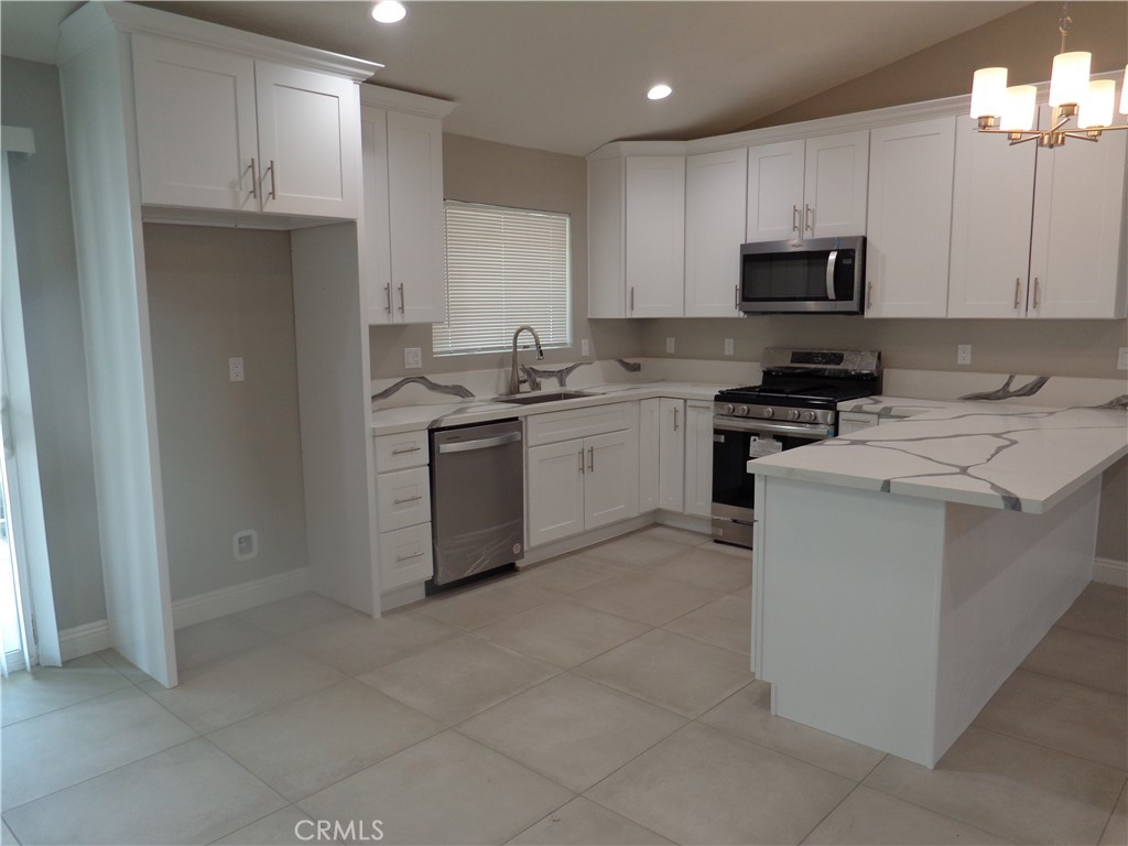 12744 Running Deer Road Apple Valley, CA 92308 - Photo 5 of 30 a kitchen with a stove sink and microwave