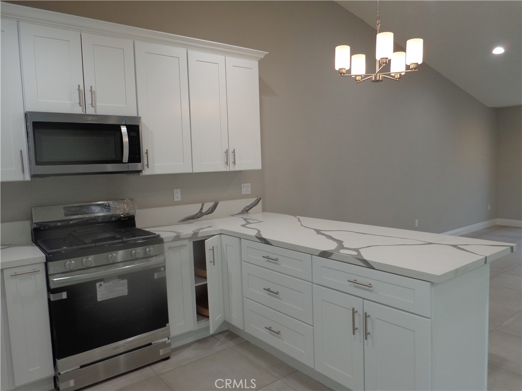12744 Running Deer Road Apple Valley, CA 92308 - Photo 9 of 30 a kitchen with white cabinets and stainless steel appliances