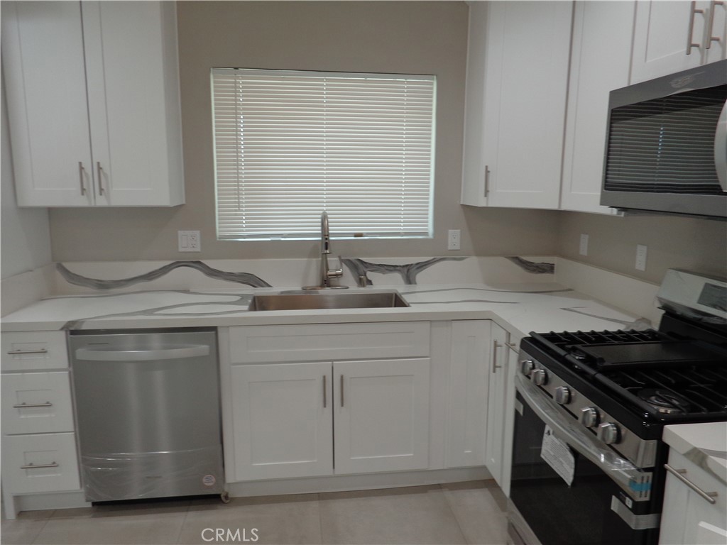 12744 Running Deer Road Apple Valley, CA 92308 - Photo 10 of 30 a kitchen with white cabinets and appliances