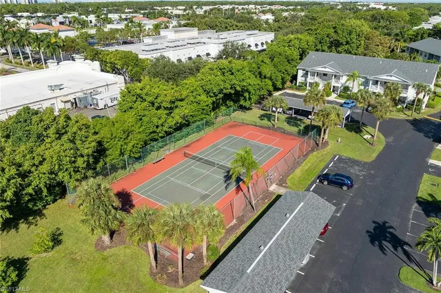 an aerial view of a tennis ground and a lots of buildings in the background