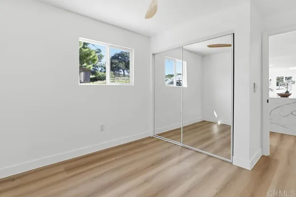 an empty room with windows and closet