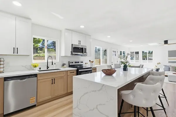 a kitchen with stainless steel appliances kitchen island granite countertop a sink and cabinets
