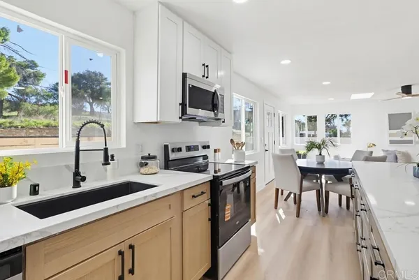 a kitchen with stainless steel appliances granite countertop a sink a stove and cabinets