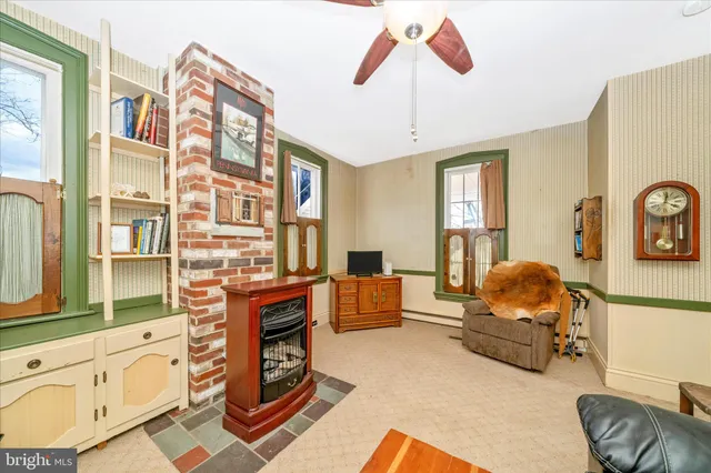 a kitchen with stainless steel appliances granite countertop a refrigerator a stove and a sink with couches