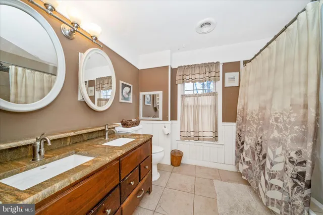 a living room with furniture a dining table and a bookshelf with wooden floor
