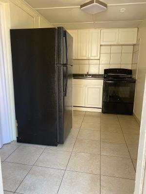 5856 Garfield Street, Unit 2 Hollywood, FL 33021 - Photo 9 of 11 a kitchen with a refrigerator and cabinets