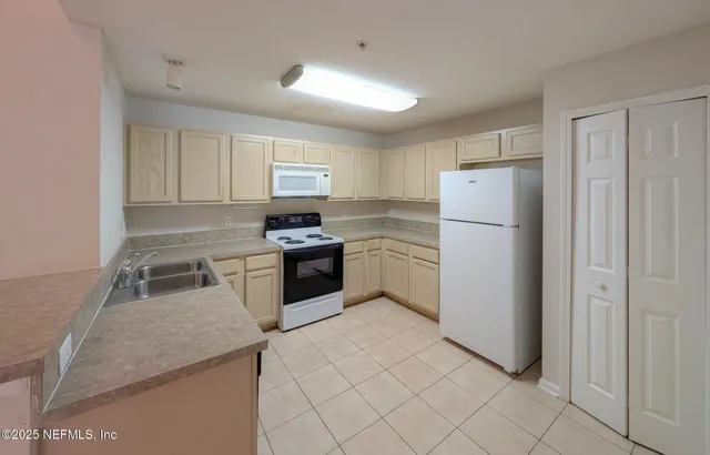 a kitchen with white cabinets and white appliances