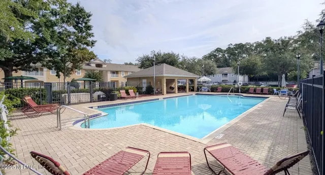 an aerial view of a house with swimming pool and furniture