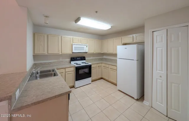 a kitchen with white cabinets and white appliances