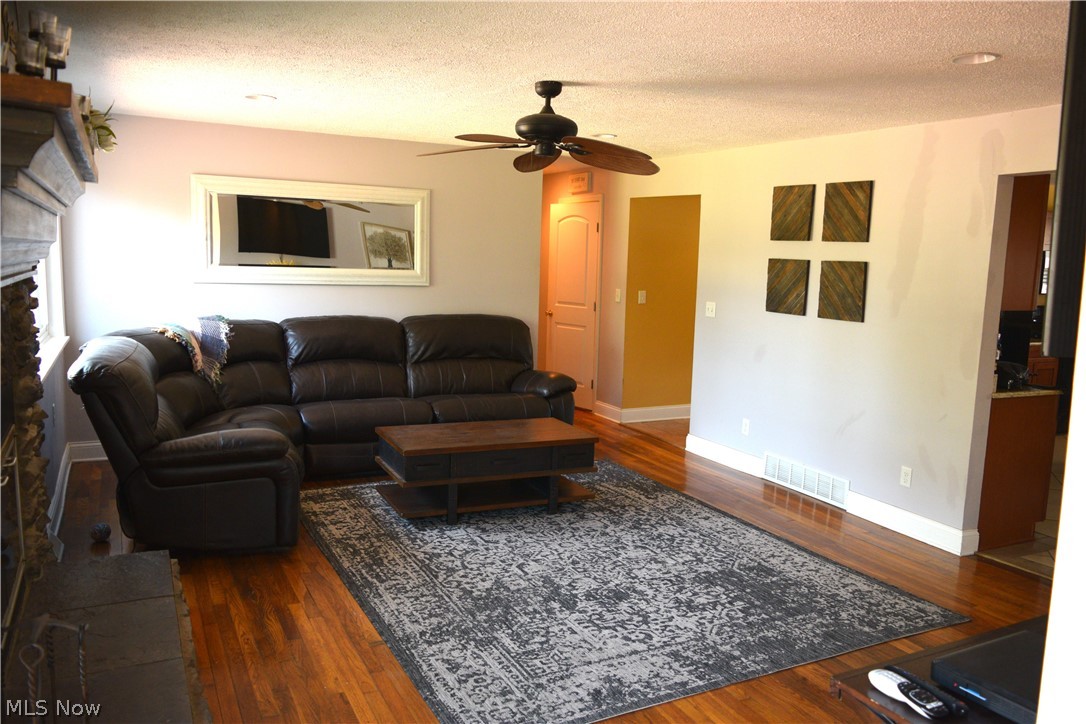 3285 Hemphill Road Barberton, OH 44203 - Photo 13 of 50 Living room featuring ceiling fan, dark hardwood / wood-style flooring, and a textured ceiling