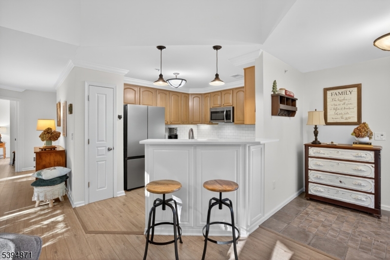 10-11 Pine Crescent, Unit 21 Vernon, NJ 07462 - Photo 23 of 50 a kitchen with stainless steel appliances kitchen island granite countertop a table and chairs in it
