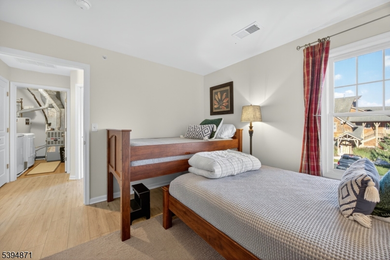 10-11 Pine Crescent, Unit 21 Vernon, NJ 07462 - Photo 35 of 50 a bedroom with a bed and a lamp