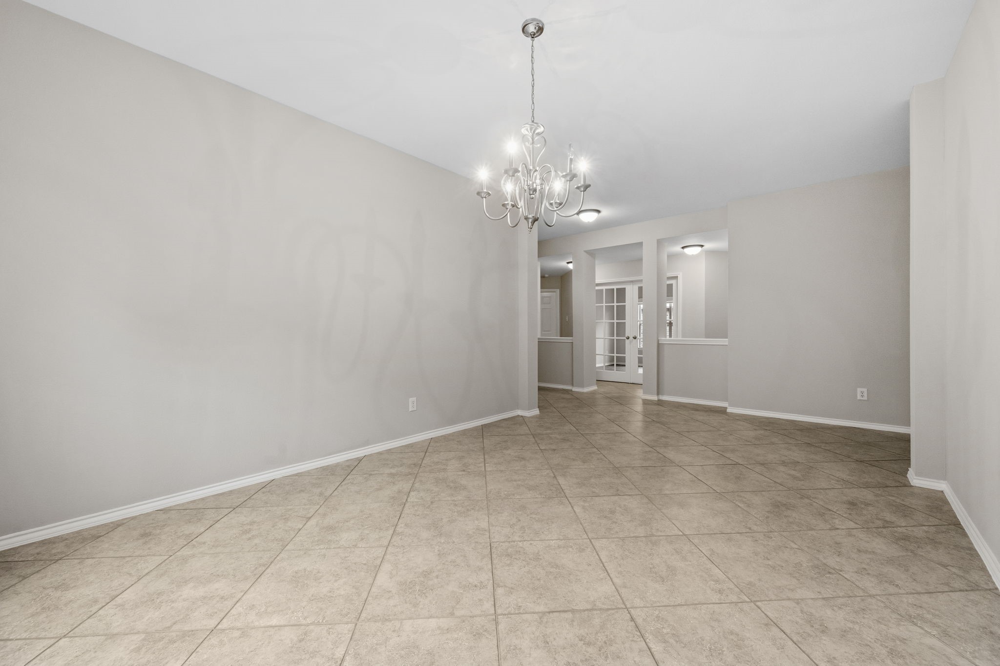 1910 Katlyn Lane Spring, TX 77386 - Photo 11 of 35 Spacious dining area with neutral tones, featuring tiled flooring and a modern chandelier.