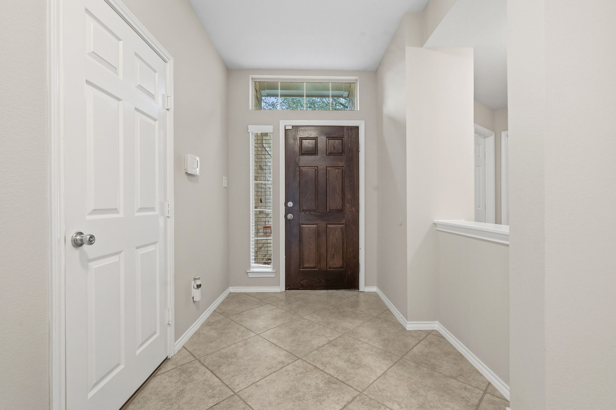 1910 Katlyn Lane Spring, TX 77386 - Photo 4 of 35 Welcoming entryway with a wood front door, side and upper windows for natural light, and tile flooring. The space is open and bright, with neutral walls and a simple, clean design.