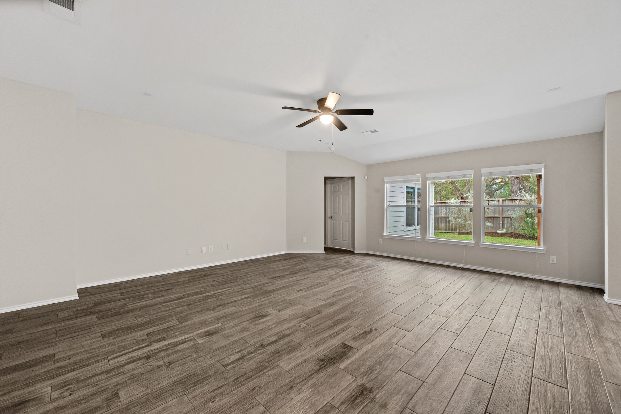 1910 Katlyn Lane Spring, TX 77386 - Photo 7 of 35 This spacious living room features elegant wood-look tile flooring, a modern NEW ceiling fan, and ample natural light from large windows overlooking the backyard.