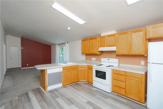 a kitchen with stainless steel appliances granite countertop a stove and white cabinets