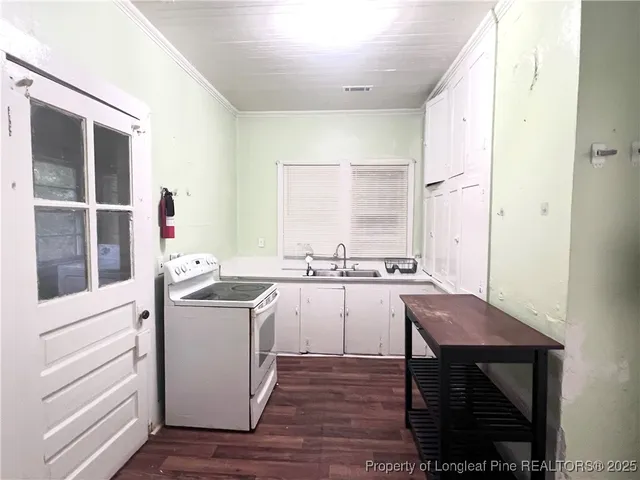 a kitchen with a stove a refrigerator and a window