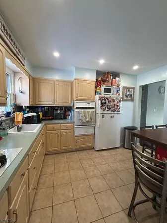 a kitchen with granite countertop a refrigerator and a stove top oven