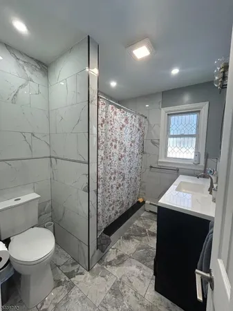 a bathroom with a toilet sink vanity and shower
