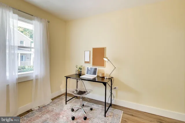 a view of a workspace with furniture and a window