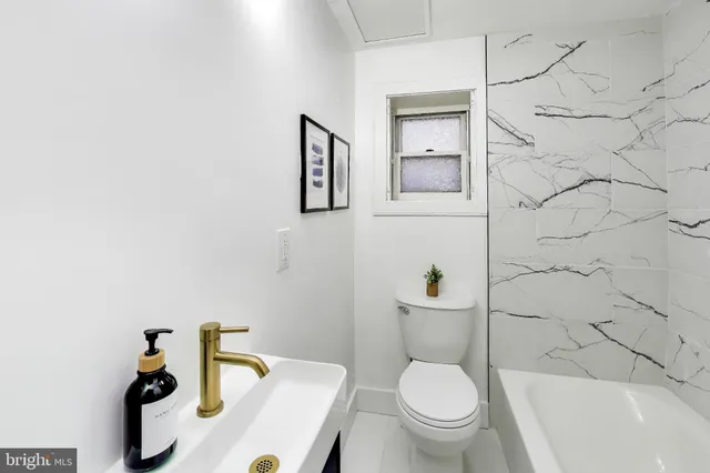 a white toilet sitting next to a bathroom sink and a shower